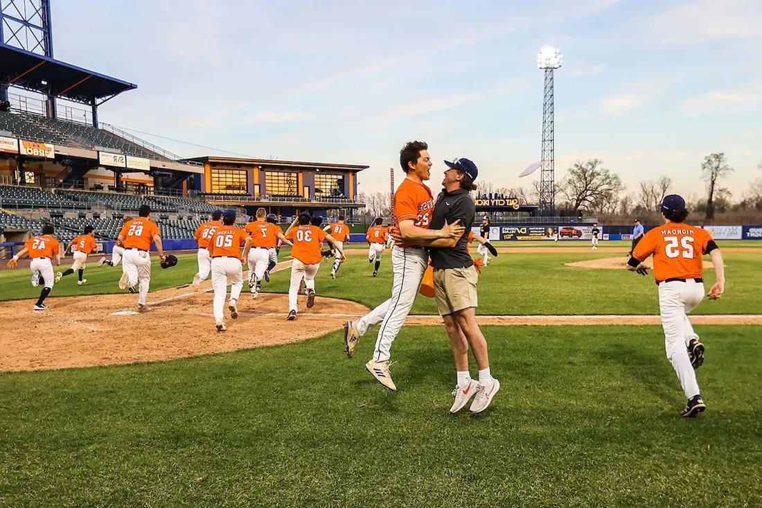 Two people chest bumping on a field.